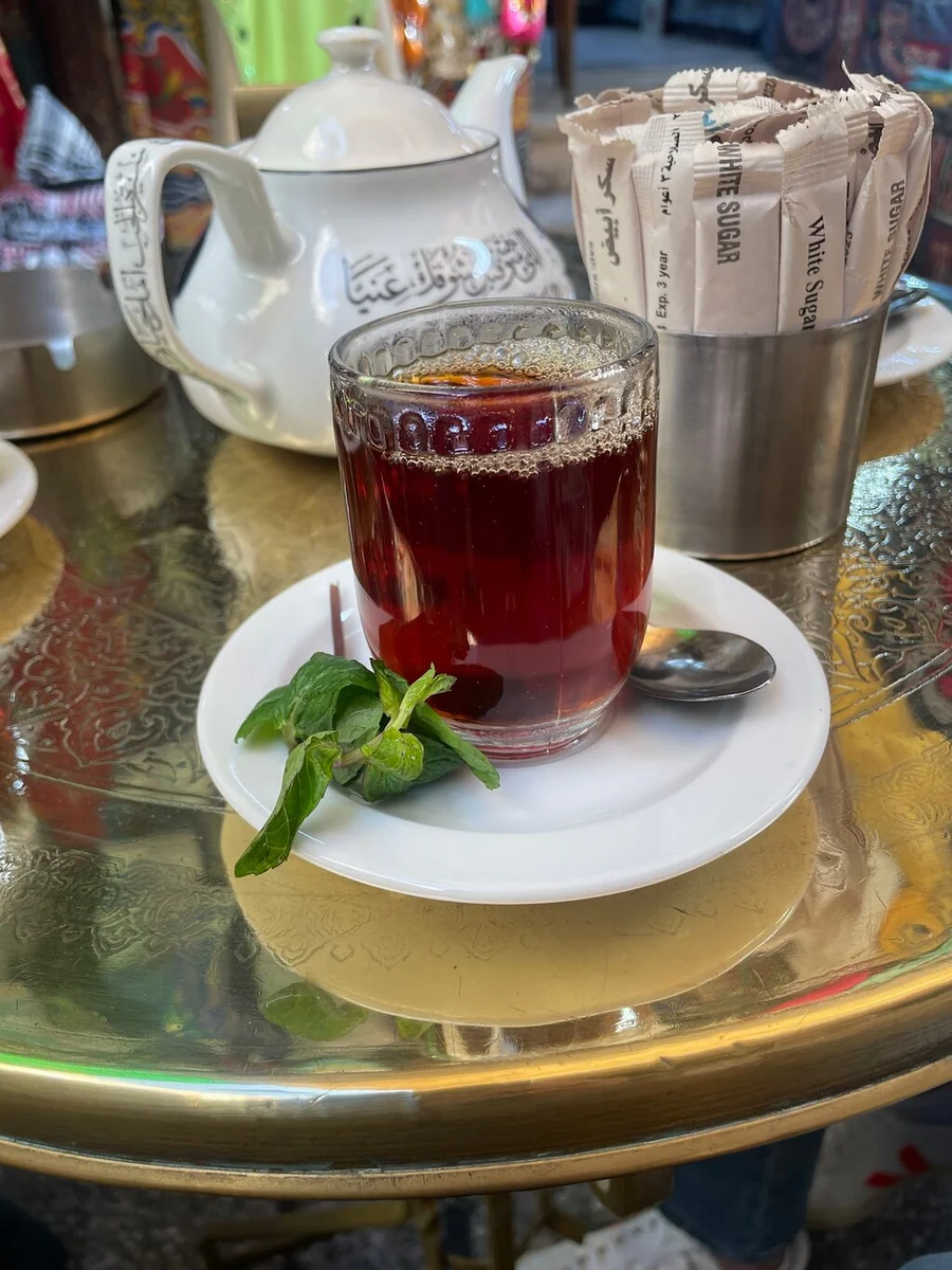 A glass of tea with fresh mint leaves on a café table