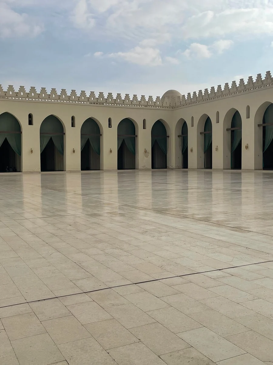 The arcades around the marble courtyard of Al-Azhar Mosque under a pale sky